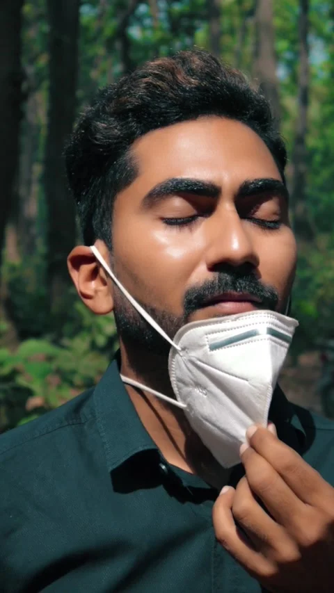 A Man breathing fresh air in forest after removing his face mask during pandemic Stock Footage 150791079