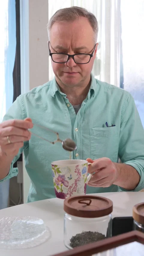 A man is brewing organic tea using a tea infuser. Stock Footage 302907204