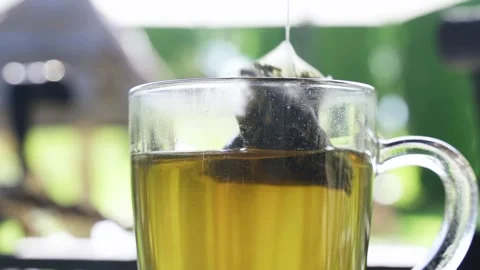 A man brews green tea in a triangular bag in a cup. Stock Footage 254428811