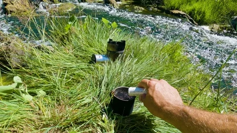 A man brews tea in nature by the river 库存影片 199190402