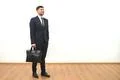 The man with a briefcase standing on the white wall background Photo