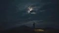 The man with a bright firework stick running on a night mountain 4k or 4k+ Resolution