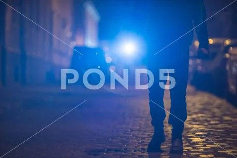 The man with a bright flashlight stand on the road. Evening night time Stock Photos