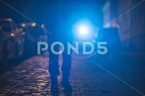 The man with a bright flashlight stand on the road. Evening night time Stock Photos