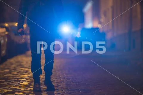 The man with a bright flashlight stand on the street. Evening night time Stock Photos