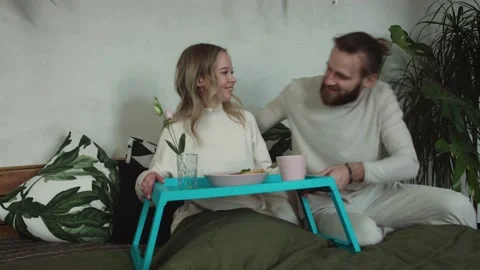 Man Bring a breakfast in Bed with present Beautiful smiling couple at home Stock Footage 147035724