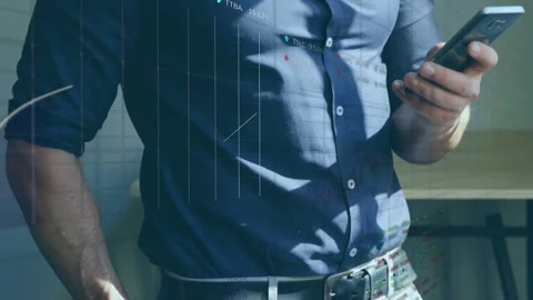 Man bringing phone into frame and tapping to check market data, charts and Stock Footage 333145399