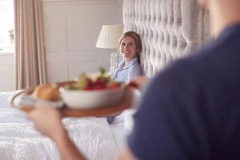 Man Bringing Woman Breakfast In Bed To Celebrate Wedding Anniversary Stock Photos