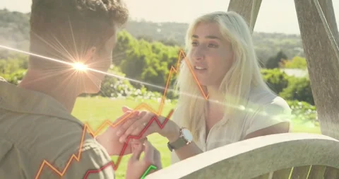Man bringing woman's hand sliding ring onto finger proposing while tech graphs Stock Footage 331634673