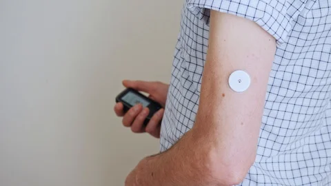 A man brings to the hand the reading device to the sensor for measuring glucose Stock Footage 93708563