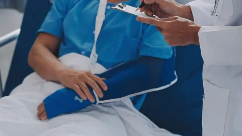 Man with broken arm in cast lying on bed in hospital. The emergency center .. Stock Footage 237356805