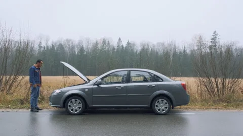 Man a broken car and opens the hood in the forest. The car suddenly broke down Stock Footage 142783726