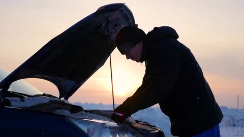 Man with broken car on side of winter road. Sunset time Video stock 71985200