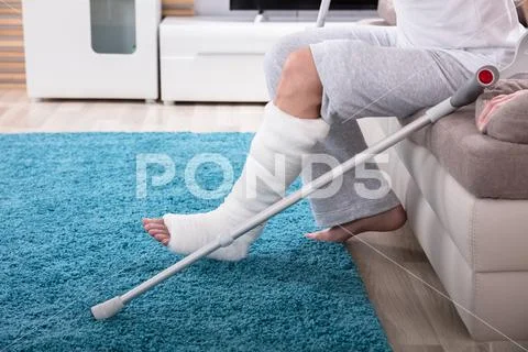 Man With Broken Leg Getting Up From Sofa Stock Photos