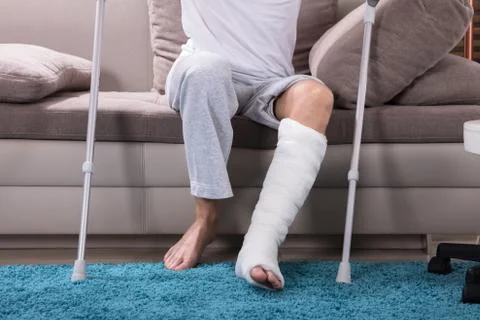 Man With Broken Leg Getting Up From Sofa Stock Photos