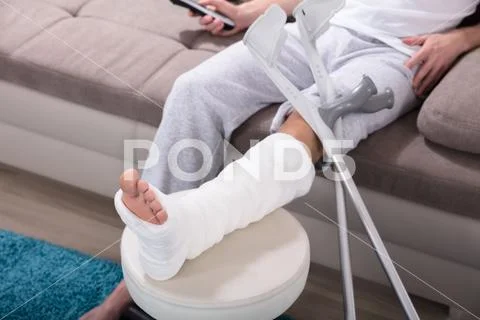 Man With Broken Leg Sitting On Sofa Stock Photos
