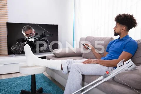 Man With Broken Leg Watching Television Stock Photos