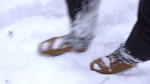A man in brown boots walks through large snowdrifts in winter in the forest Stock Footage 148457252