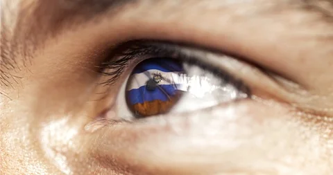 Man brown eye in close up with the flag of el salvador in iris with wind motion. Stock Footage 120816595