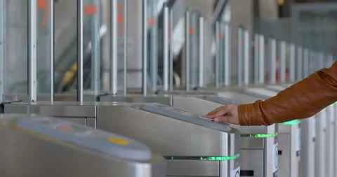 A man in a brown jacket applies a card to the turnstile and passes in the subway Stock Footage 119628209