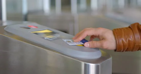 A man in a brown jacket applies a card to the turnstile and passes in the subway Stock Footage 119628391