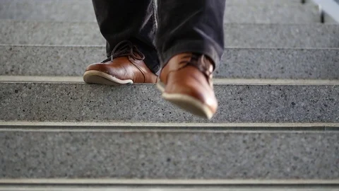Man in brown shoes coming down on stairs Stock Footage 88827996