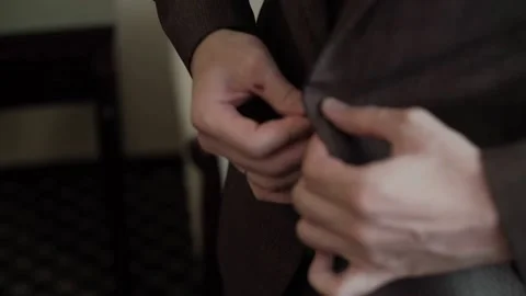Man in brown suit getting dressed and getting ready for the celebration Stock Footage 143633065