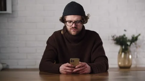 Man in brown turtleneck and gray hat texting his girlfriend. Surprised Stock Footage 264402018