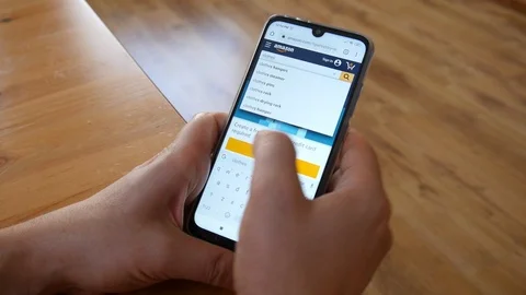A Man browse Amazon app on Mobile Sell Phone searching of Clothes Stock Footage 119373123