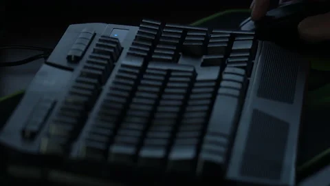 A man browses a website with a mouse in front of a computer in a dark room Stock Footage 237374712