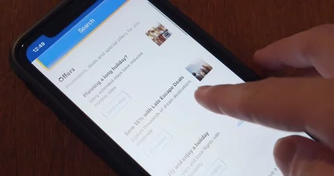 Man browsing Booking.com website seen in an iPhone Vidéo 253339510