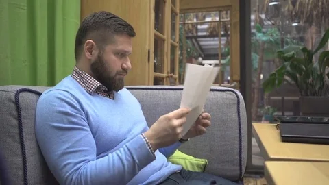 Man browsing documents, files, in pub, cafe, indoor, steadycam shot 库存影片 73076098