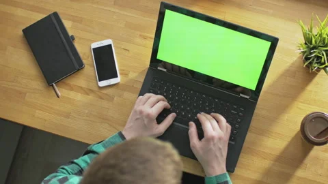 Man browsing eCommerce websites on laptop with green screen indoors Stock Footage 142854175