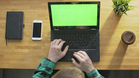 Man browsing eCommerce websites on laptop with green screen indoors Stock Footage 142856918