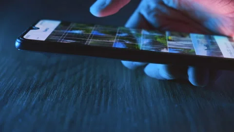 Man browsing the internet on his smartphone at night Stock Footage 236630440