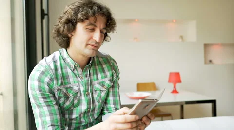 Man browsing internet on smartphone and smiling to the camera, steadycam shot 스톡 동영상 62974205