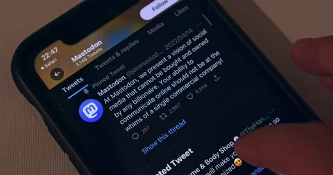 Man browsing Mastodon app its Twitter account (@joinmastodon) on an iPhone Stock Footage 221009375