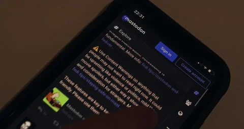 Man browsing Mastodon website (#Explore, mastodon.social) on an iPhone Stock Footage 221009562