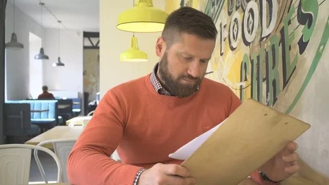 Man, browsing menu, lunchtime, sitting in cafe, steadicam 库存影片 73227882