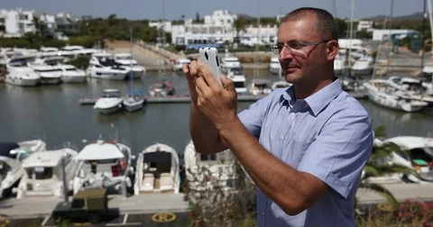 Man Browsing Mobile Phone Touch Screen Messenger in Marina Port Urban Scene View Stock Footage 81464212