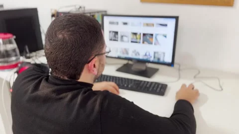 Man Browsing Online Shoe Store on Desktop Computer Vidéo 340185935