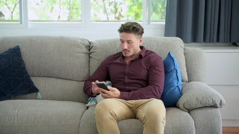 Man browsing phone on couch at home. Stock Footage 105319534