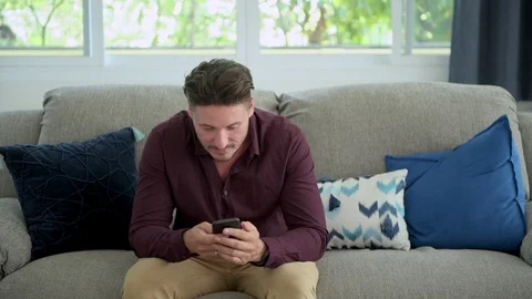Man browsing phone on couch at home. Relax mood. Stock Footage 105321746