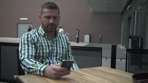 Man browsing phone at the table. Vídeo Stock 52689621