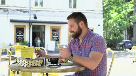 Man browsing smartphone during breakfast in cafe 库存影片 67626937