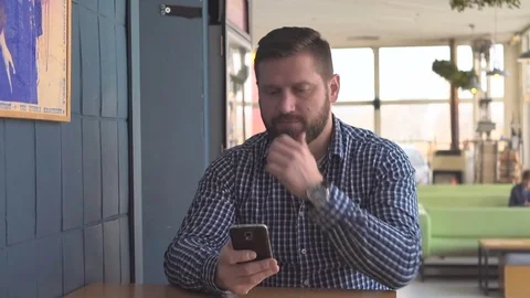 Man browsing smartphone, look at camera in cafe, portrait, steadycam shot  库存影片 72950942