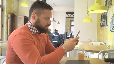 Man browsing smartphone, profile, indoor, in cafe, steadycam shot Vídeo Stock 73266429