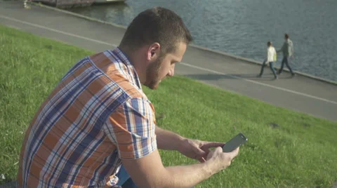 Man browsing smartphone by the river Vídeos de archivo 52717905