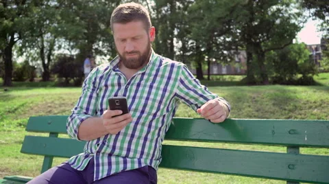 Man browsing smartphone smiles for camera. Steadicam. 库存影片 67235438