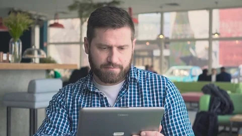 Man browsing tablet computer, cafe, portrait, steadycam shot Vídeo Stock 72947436